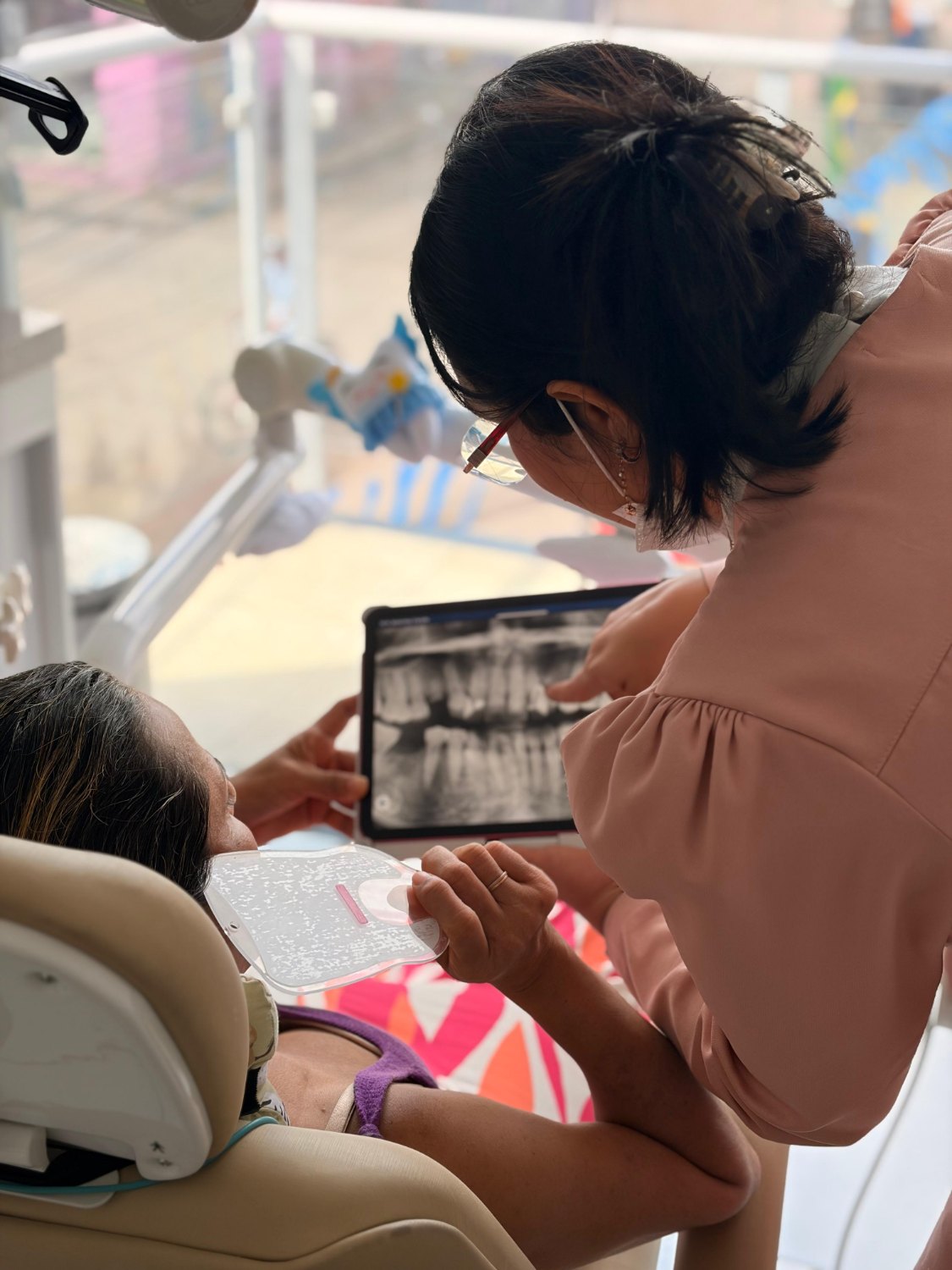 Análise de exame em consultório, tablet com radiografia em mãos.