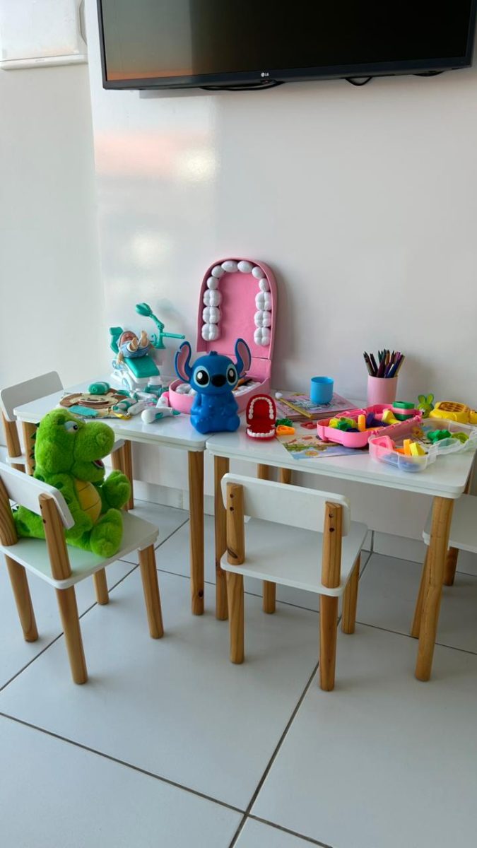 Espaço kids com mesa e brinquedos.