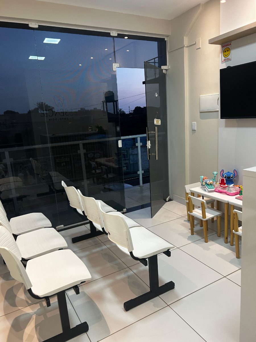 Sala de espera com poltronas e cantinho para crianças.